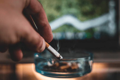 Un homme qui fume sa dernière cigarette. Il arrête du fumer grâce au laser anti-tabac